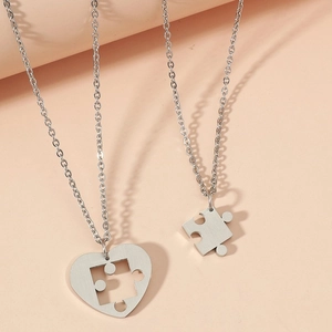 Dettaglio delle collane per coppie con ciondolo a cuore e pezzo di puzzle in argento