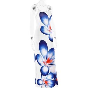 Détail d'une robe longue blanche à grandes fleurs bleues et accents orange