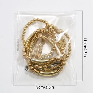 Detailed view of layered gold beaded heart bracelets in clear packaging with dimensions