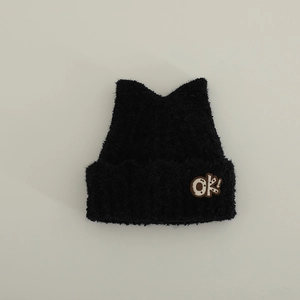 Detailed view of black plush cat ear hat with ok! letter embroidery and knit texture