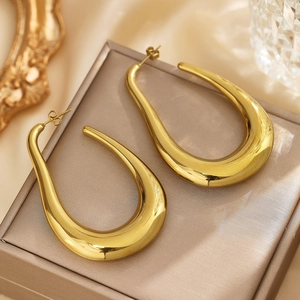 Polished gold U-shaped teardrop earrings displayed on a luxury jewelry box with frame