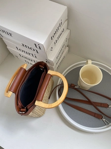 Detailed top view showing internal structure and wooden handles of beige straw bucket bag