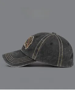 Détail de la casquette de baseball vintage en denim gris avec surpiqûres jaunes