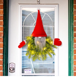 Close-up of lighted Christmas gnome wreath with red hat and warm white LED decor