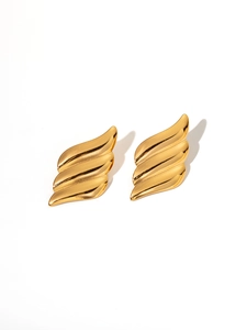 Close-up of golden wavy geometric titanium steel stud earrings on white background