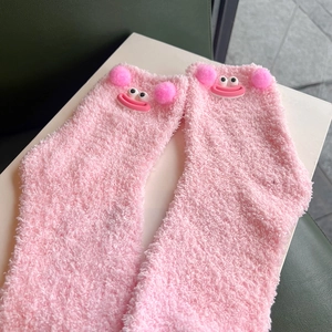Cute pink coral fleece mid-calf socks with cartoon eyes and 3D plush ball accents