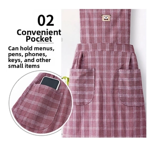 Detail of red checkered cotton apron featuring cute bear patch and functional side pockets