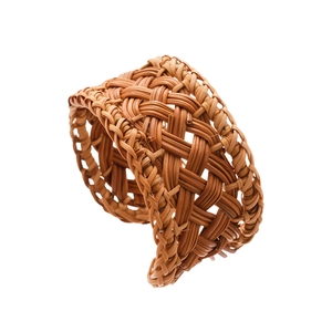 Handcrafted rattan woven napkin ring in natural wood color with geometric mesh texture