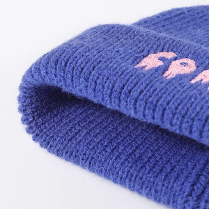 Dark blue ribbed knit beanie featuring pink embroidered lettering for winter fashion