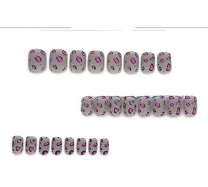 Détail de faux ongles courts carrés-ovales gris mats avec motifs léopard roses