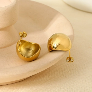 Macro shot of 16K gold-plated stainless steel teardrop earrings on a beige ceramic tray