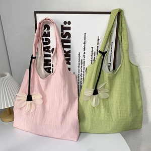 Detail of colorful pleated canvas tote bags with soft texture and flower charm