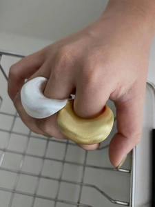 Detail van matgouden en zilveren geborstelde open ringen met minimalistisch gebogen design