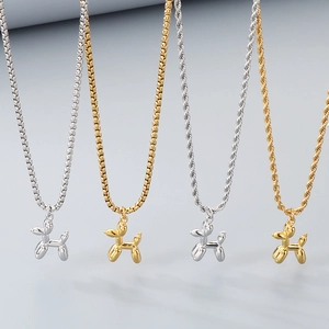 Détails des pendentifs chien ballon or et argent sur des chaînes perles et torsadées
