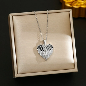 Close-up of heart wings pendant with black and white pavé zircons on jewelry box