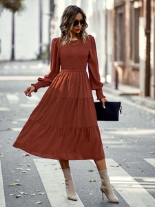 Détail d'une robe midi orange brûlé à volants avec buste froncé et manches longues