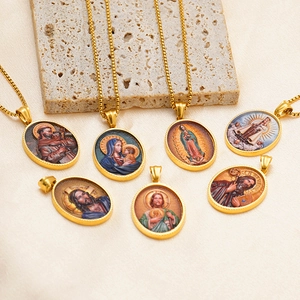 Detailed view of 18k gold plated oval religious pendants with vintage saint engravings