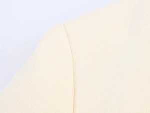 Macro shot of precise stitching and fine woven texture on beige longline blazer