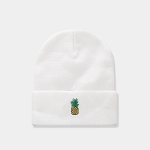 Close-up of white knitted beanie featuring detailed yellow and green pineapple embroidery
