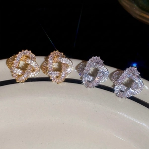 Gold and silver twisted knot stud earrings with shimmering cubic zirconia stones
