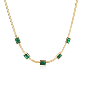 Golden snake chain necklace with five rectangular emerald green zircons on white backdrop