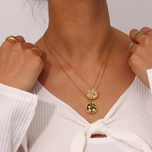 Detail of layered gold necklaces with celestial coin pendants and star patterns