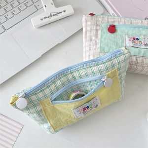 Close-up of checkered fabric pencil cases with front pockets and ring zippers
