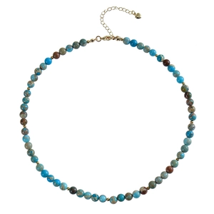 Detail of bohemian natural stone necklace with blue tiger eye beads and gold heart pendant
