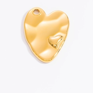 Macro detail of 18k gold heart pendant featuring irregular texture and embossed relief