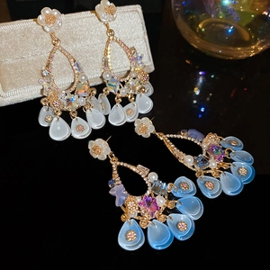 Detail of luxury flower earrings with pearl tassels and sparkling crystals in two colors