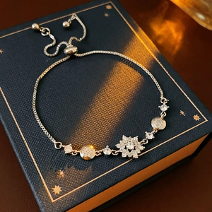 Détail du bracelet flocon de neige réglable avec zircons sur un coffret bleu luxe