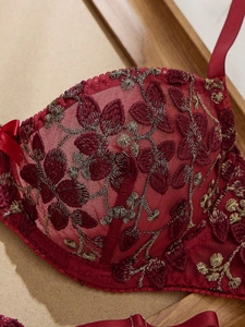 Broderie détaillée de dentelle bordeaux et fil doré sur le bonnet d'un soutien-gorge