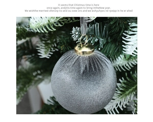 Close-up of a grey velvet Christmas ball ornament hanging on a tree with a gold ring