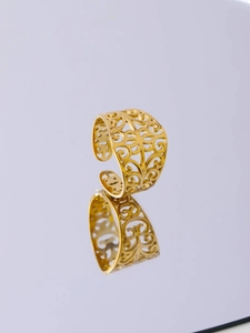Macro shot of gold mesh cutout ring featuring irregular texture and elegant mirror reflection