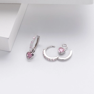 Macro shot of silver heart earrings with pink zircon stone and small diamond details