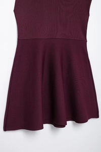 Detailed view of dark purple knitted dress with A-line skirt texture and waist seam