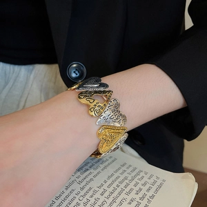 Detail of vintage heart-shaped metal bracelet with Live Laugh Love engraved text
