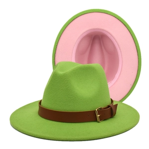 Detail of wide brim fedora hat featuring contrast green exterior and pink lining
