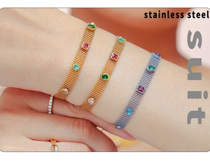 Detailed macro view of gold and silver stainless steel mesh bracelets with colorful gemstones