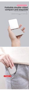 Macro view of a compact foldable double-sided metal makeup mirror fitting into a pocket