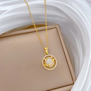 Macro detail of gold cat necklace with white opal and pavé crystals on jewelry box