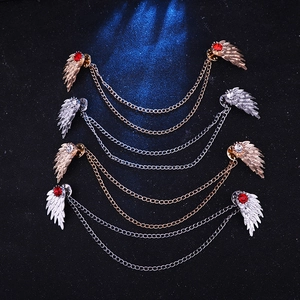 Detailed macro view of four wing-shaped collar pins with rhinestones and double chains