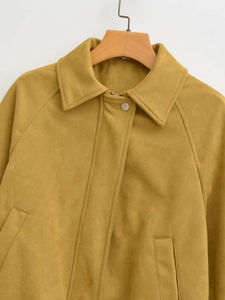 Detail einer ingwergelben Wildleder-Bomberjacke mit Reverskragen an einem Holzbügel