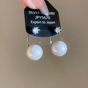 Macro view of S925 sterling silver earrings with zircon and large round white pearl