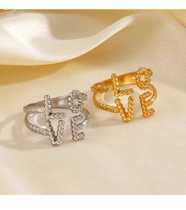 Dettaglio macro degli anelli LOVE in oro 18K e argento su tessuto di seta gialla