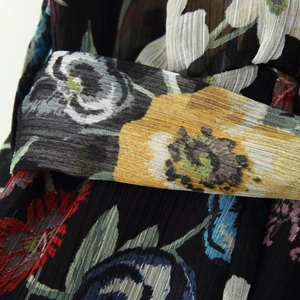 Robe en mousseline fleurie noire avec texture plissée et motifs floraux vintage colorés