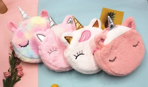 Détail de quatre sacs licorne en peluche colorés avec cornes pailletées et broderies