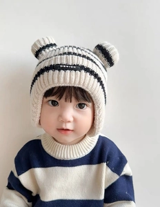 Close-up of baby knit hat with bear ears and matching navy blue striped sweater