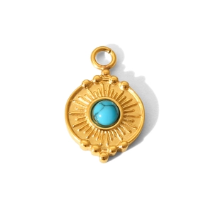 Detailed macro of golden palm eye pendant with blue turquoise stone and sunburst motif