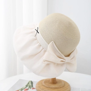 Elegant beige straw hat with a large cream chiffon bow and wide brim for sun protection